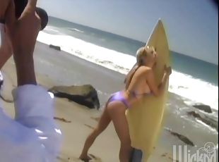 Pleasurable blonde with huge boobs poses on a beach