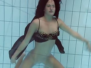 Gypsy girl with dark hair swimming underwater