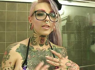 Tattooed alternative chick in a swimsuit talking about her fantasies