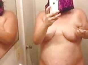 Chubby amateur brunette writes on her big tits in front of a mirror