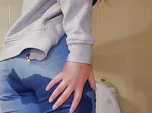 Girl with great ass pees in her jean pants and plays with her wet pussy 