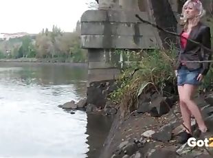 Blonde girl climbs down to the river to piss